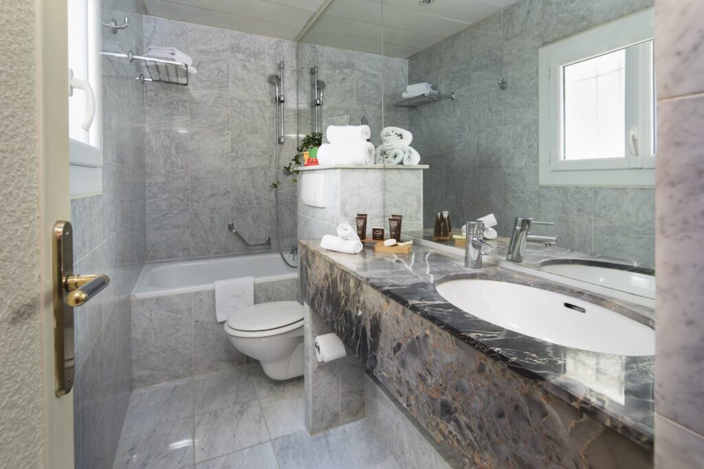 salle de bain en marbre hotel calme Paris avec baignoire, lavabo et toilettes