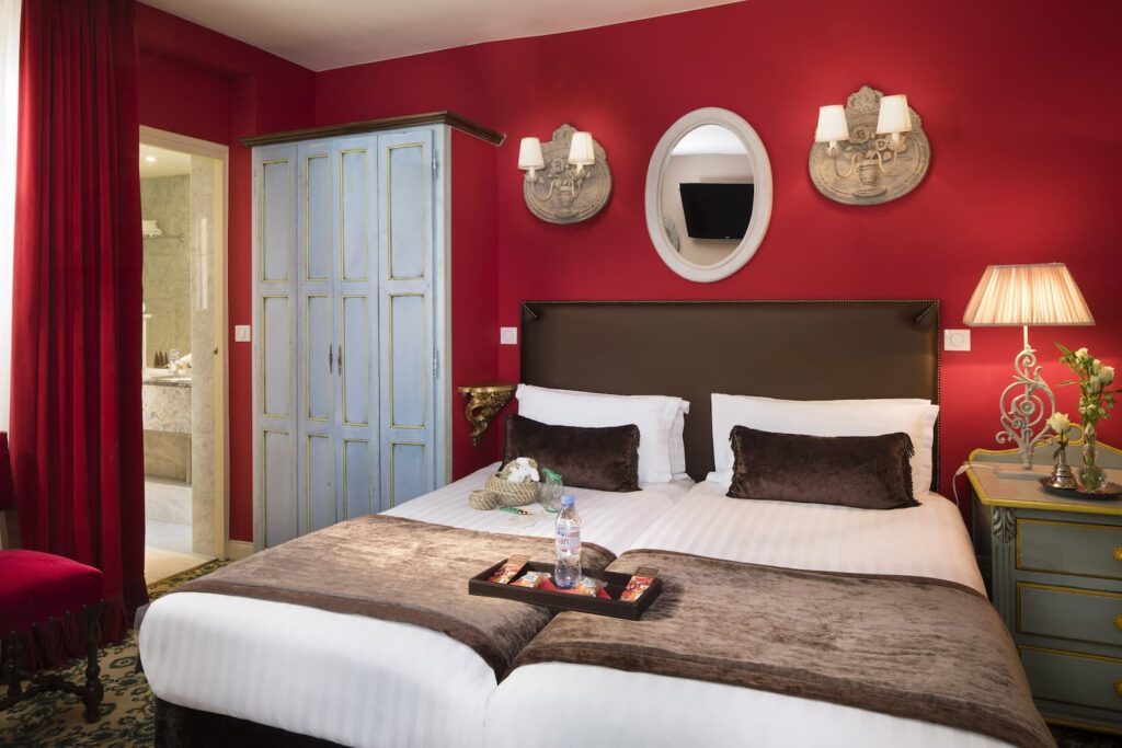 deux lits individuels, tissus rouge et placard bleu, hôtel calme paris - hotel des 2 Continents