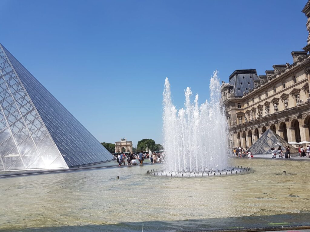 Louvre Museum, fountain and pyramid on a sunny day - romantic weekend - hôtel des 2 continents Paris 6