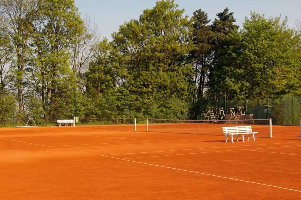 Hôtel Roland Garros Paris: Terrain de tennis en terre battue. En arrière plan nous observons un cadre verdoyant qui fait de ce terrain un lieu tout à fait charmant.
