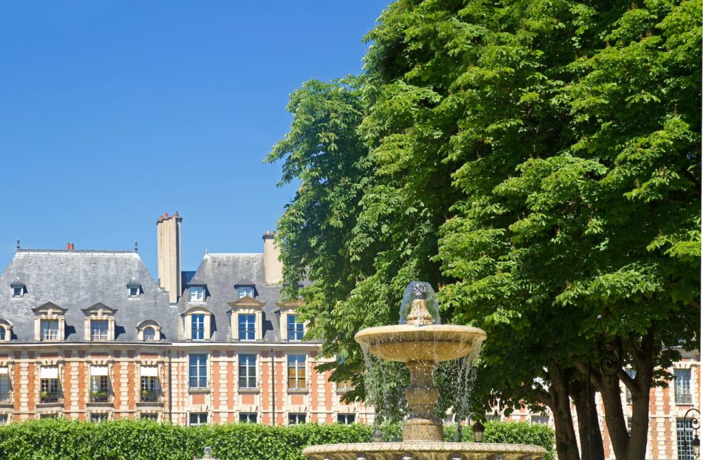 Séjour calme à Paris - Maison de Victor Hugo. Nous apercevons la maison de Victor Hugo depuis la Place des Vosges. Au premier plan, il y a une jolie fontaine, et au dernier, un grand ciel bleu qui donne envie de se balader ! 